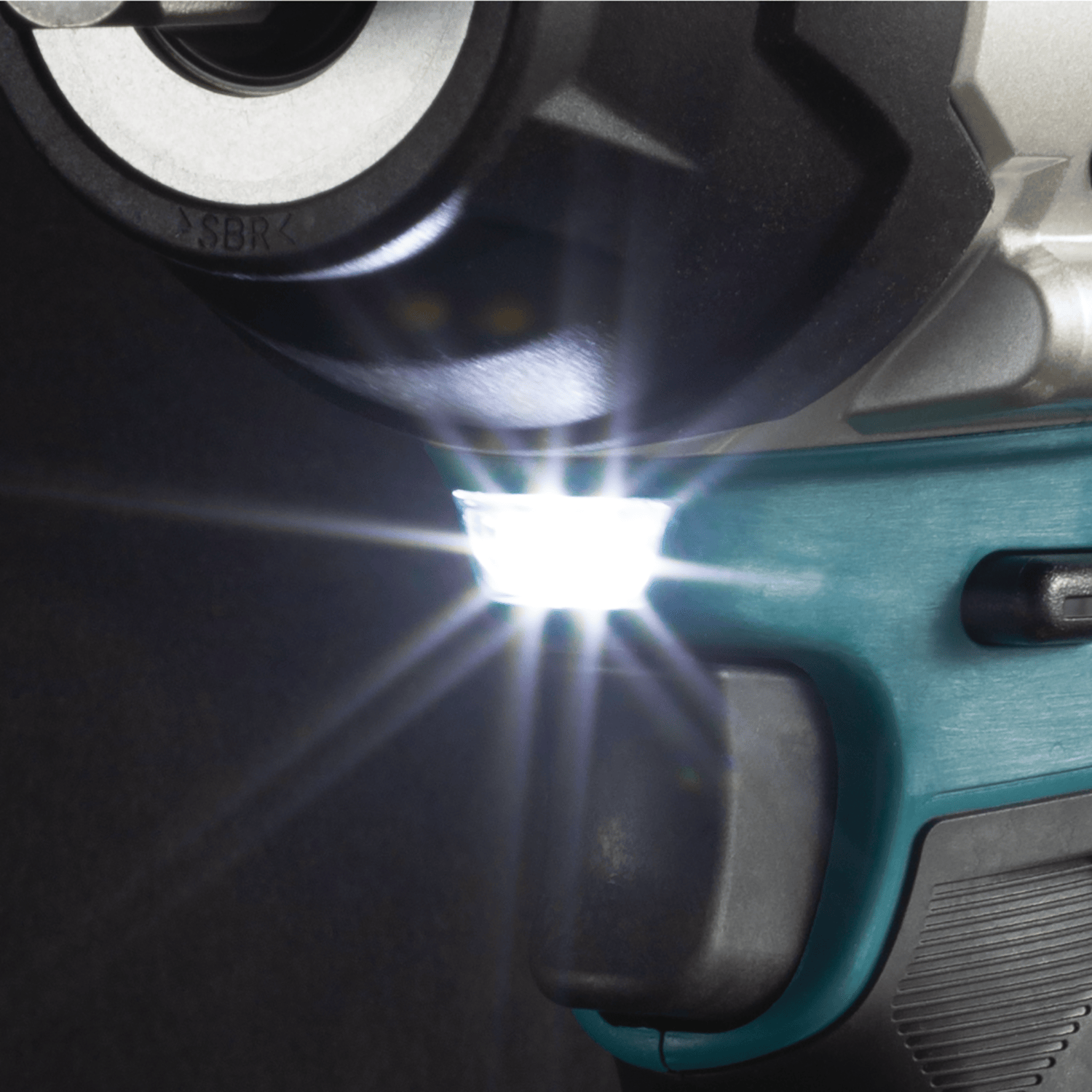 Bright LED headlight positioned below the gear housing on the Makita XWT17 impact wrench to illuminate dim workspace fasteners.