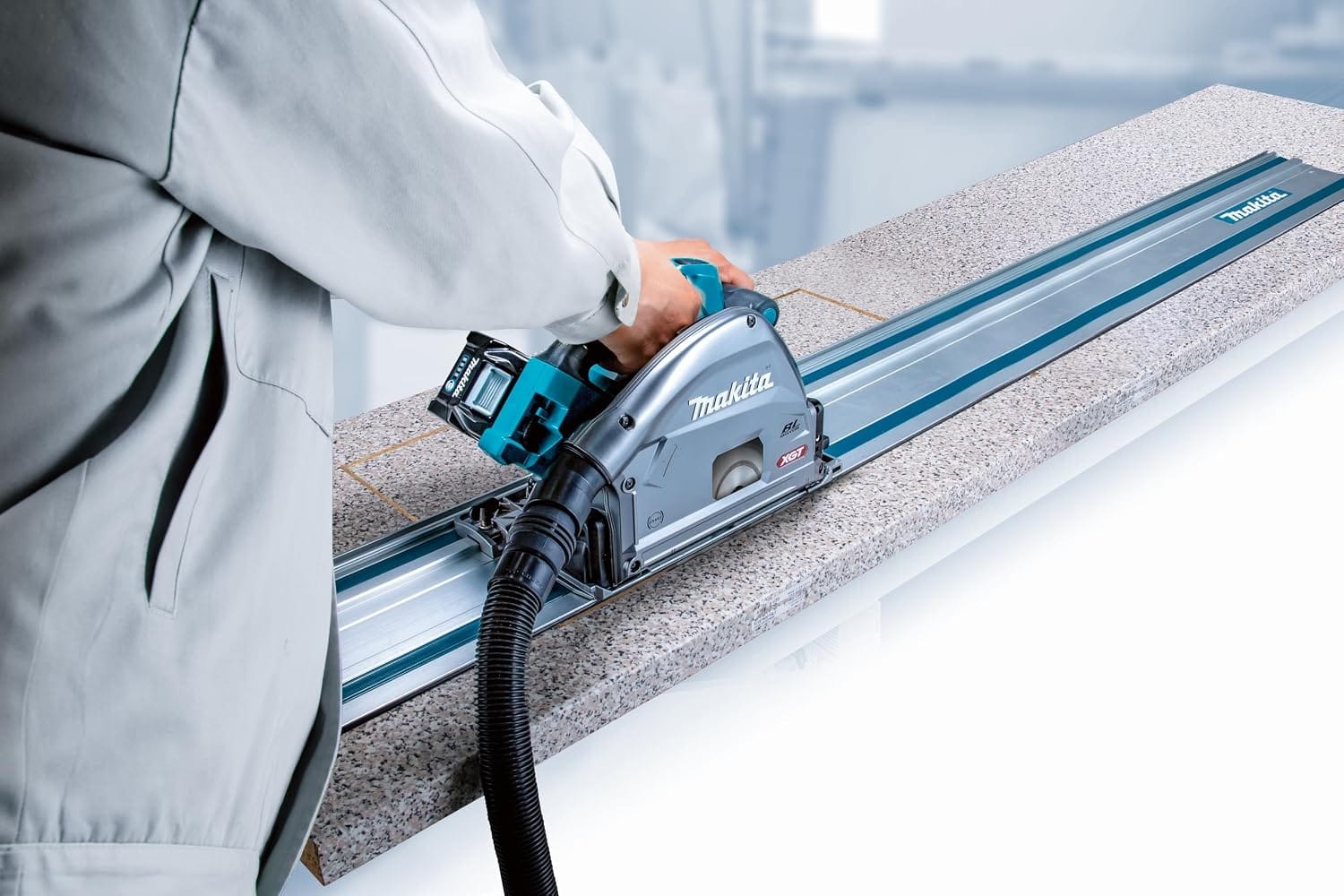 Cordless XGT plunge saw sliding on a 55-inch Makita track rail to perform precise, dust-controlled cuts in laminate countertops.