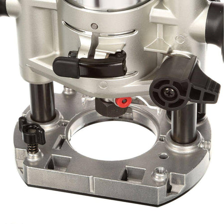 Detailed view of the plunge base attachment included in the Makita RT0701CX3 compact woodworking router kit, highlighting the plunge lock lever, quick-release cam lock, and precision depth adjustment components.