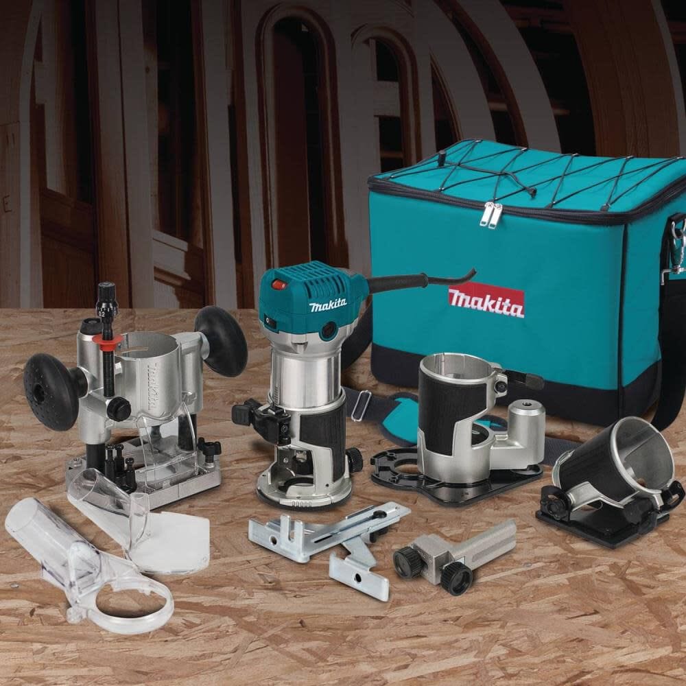 Complete Makita RT0701CX3 variable speed compact woodworking router kit laid out on a workbench, featuring the 6.5 Amp router, four specialized bases, edge guides, dust extraction attachments, and a durable teal tool bag.