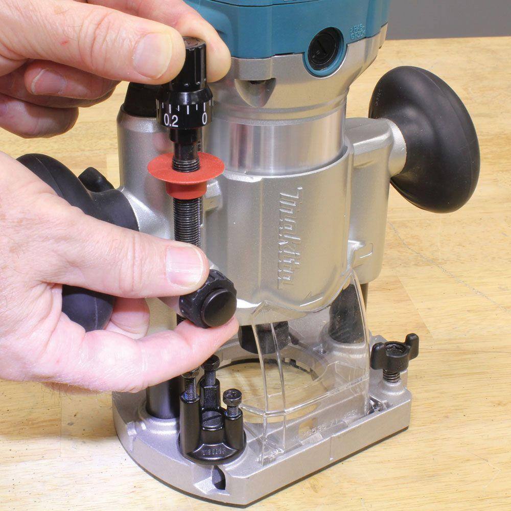 Close-up of a user adjusting the easy-to-use fine depth adjustment rod on the plunge base of the Makita RT0701CX7 compact router.