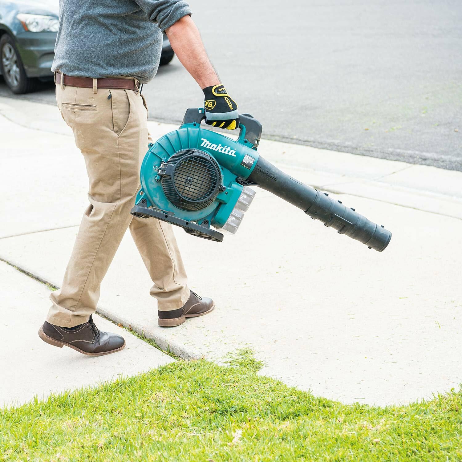 User carrying the Makita XBU04Z cordless blower by their side while walking on a sidewalk, demonstrating the lightweight and balanced design for easy transport.