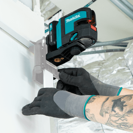 Tradesman adjusting the magnetic bracket height of the Makita SK105D laser mounted onto a metal wall track for drop ceiling alignment.