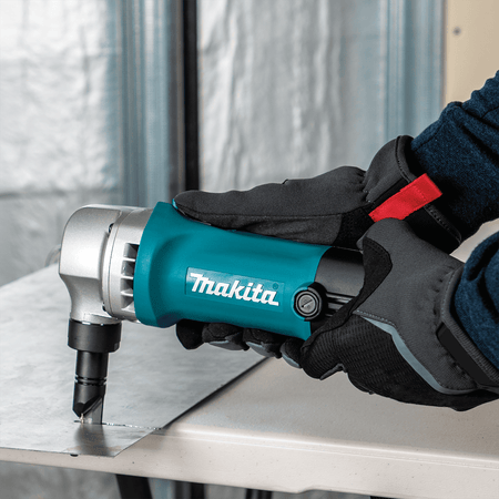 Operator cutting flat sheet metal with the Makita JN1601 nibbler to make clean, distortion-free straight shears.