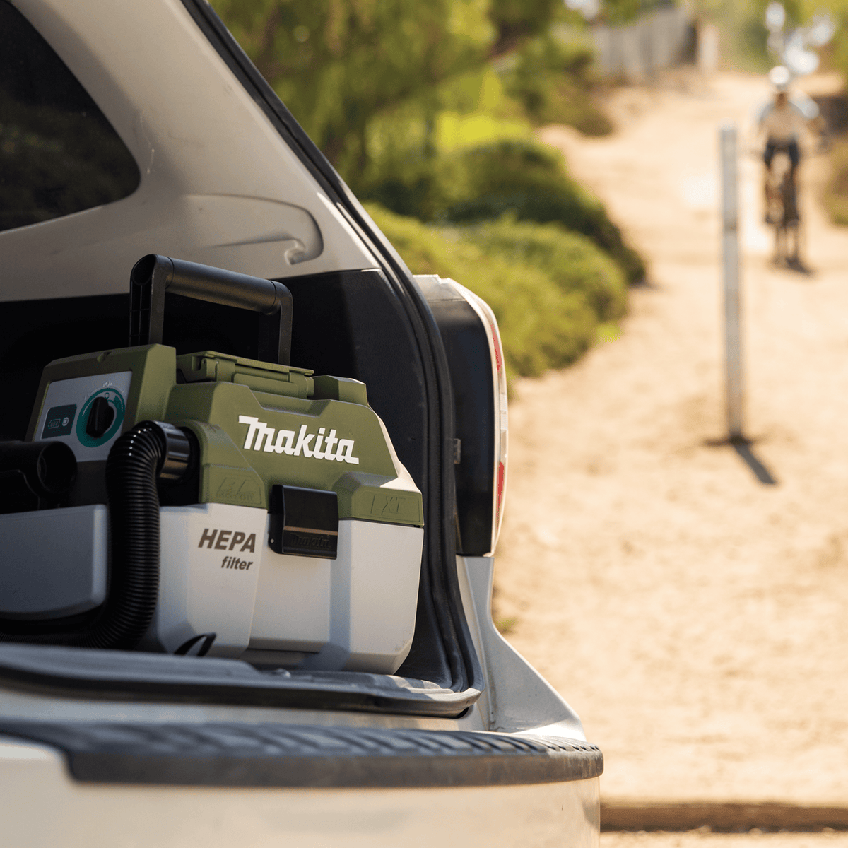 Makita ADCV11Z 18V LXT HEPA filter vacuum stored in a vehicle trunk for quick access during outdoor recreational trail trips.