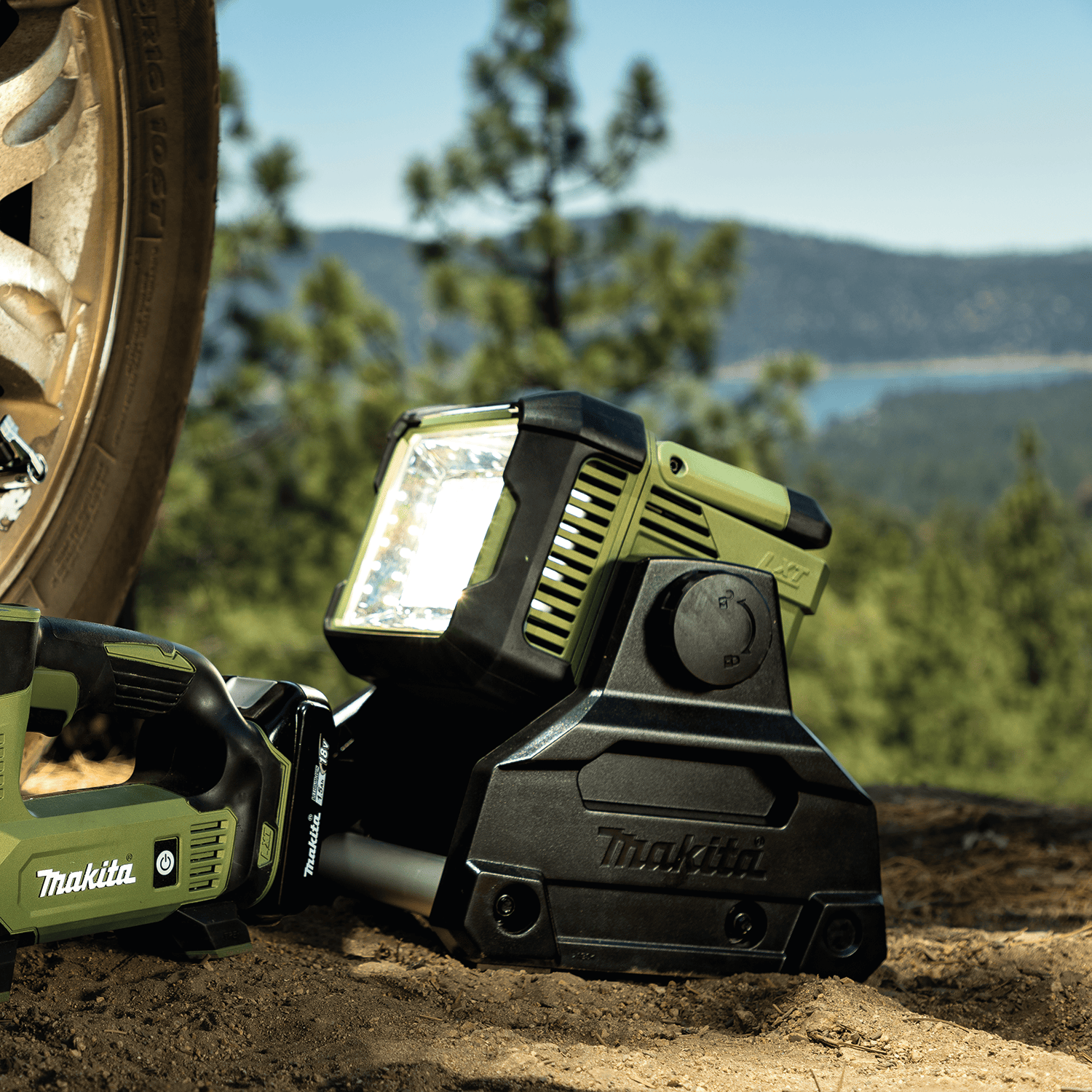 Makita ADML811 Outdoor Adventure 18V LXT area light angled upward to illuminate off-road vehicle tires and outdoor work environments.