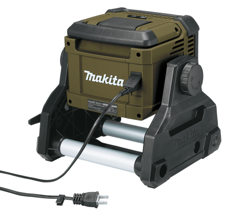 Rear view of the Makita ADML811 work light showing the 120V AC power cord plugged into the sealed AC port for continuous hybrid operation.