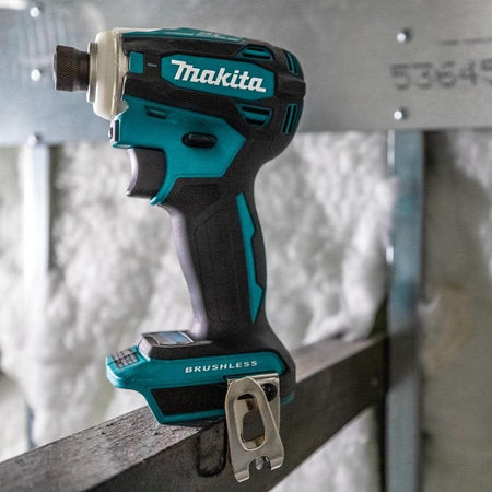 A side perspective of the Makita XDT19Z impact driver positioned on a structural metal beam, showcasing its compact form factor and professional teal finish.