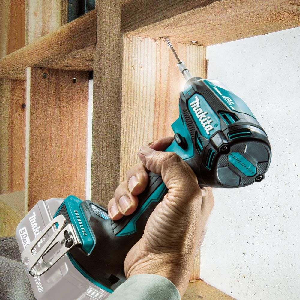 An action photo showing the Makita XDT19Z impact driver driving a long screw into a wooden 2x4 stud, emphasizing the tool's precision and power in framing applications.