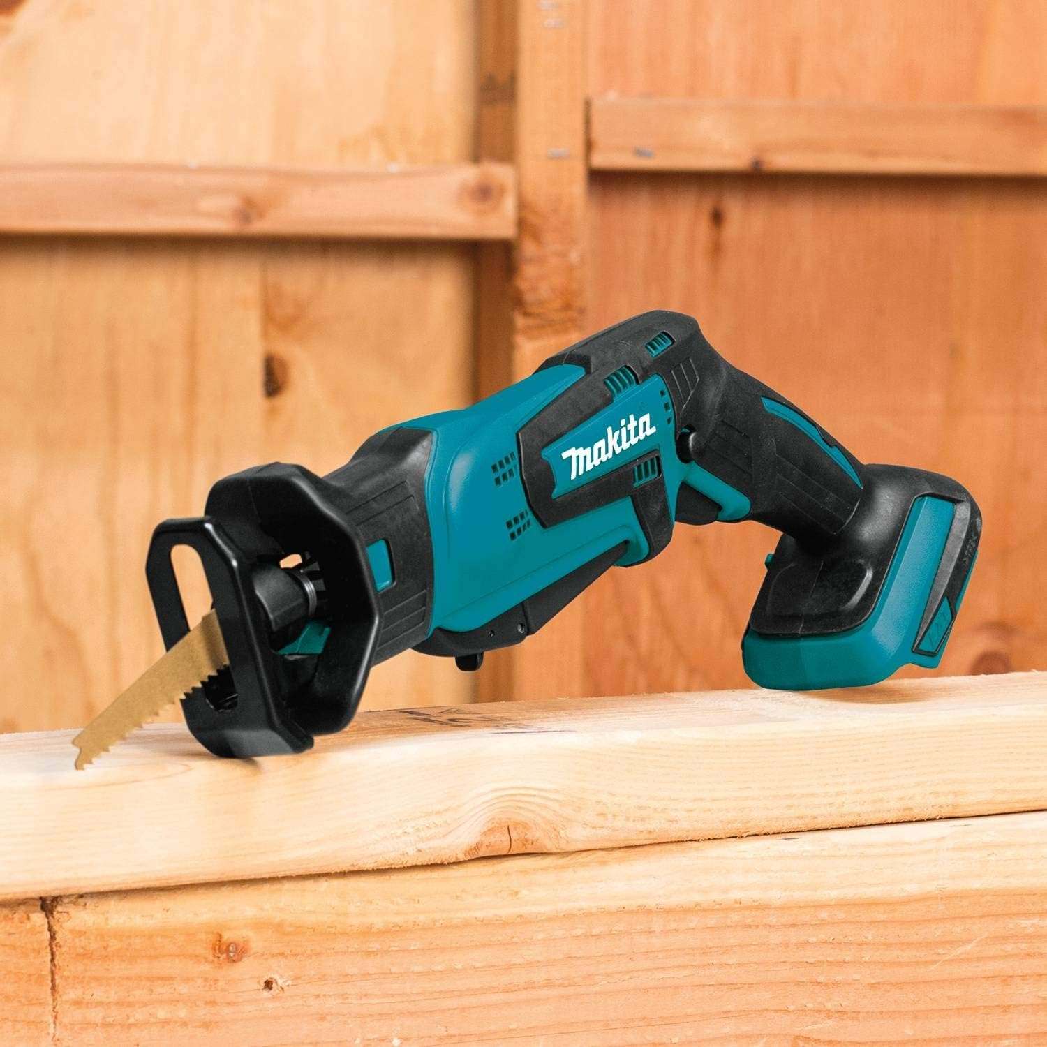 The Makita XRJ01Z 18V LXT cordless compact reciprocating saw resting securely on a wooden 2x4 framing stud on a construction site, ready for wood demolition.