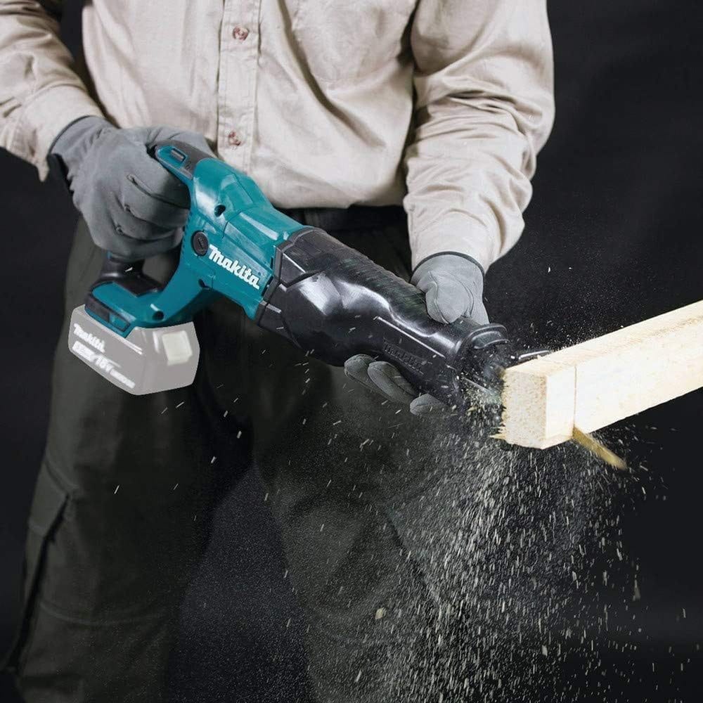 A construction worker using the cordless reciprocating saw to cut through a wooden beam, creating a spray of sawdust.