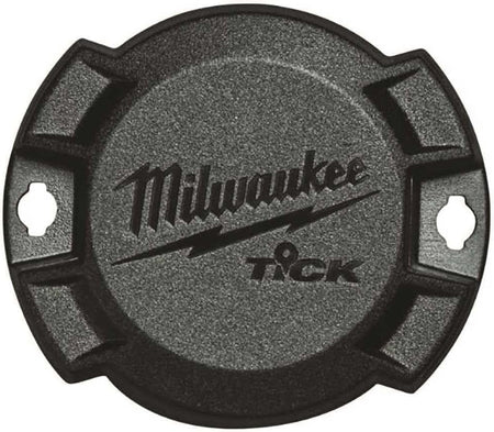 Top-down close-up view of the circular black Milwaukee TICK tracker showing the textured surface, logo, and side mounting holes.