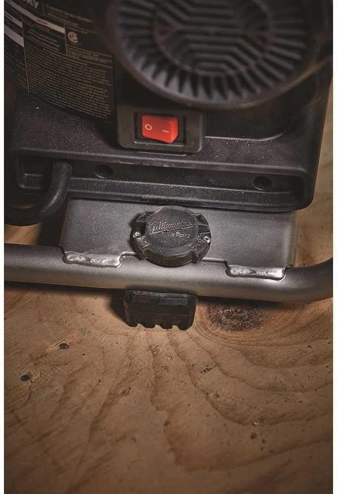 Close-up view of the TICK tracker riveted securely to the grey metal frame of a piece of heavy equipment.