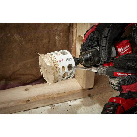 Close-up of a user inserting a screwdriver into the All-Access side slots of the hole saw to easily pry out a stuck wood plug.