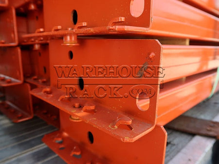 A detailed close-up shot of the universal teardrop shaved-pin end connectors and safety locking pins on the end of a high-capacity 5 15/16-inch face orange industrial load beam.
