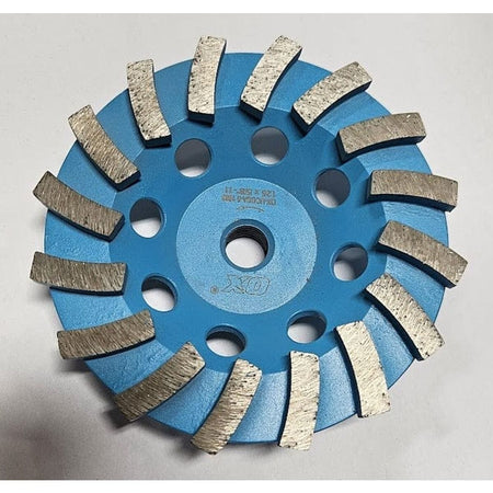A top-down view of the OX Tools 5-inch single row diamond cup grinder featuring blue steel construction and aggressive spiral-segmented diamond teeth for heavy-duty concrete and stone grinding.