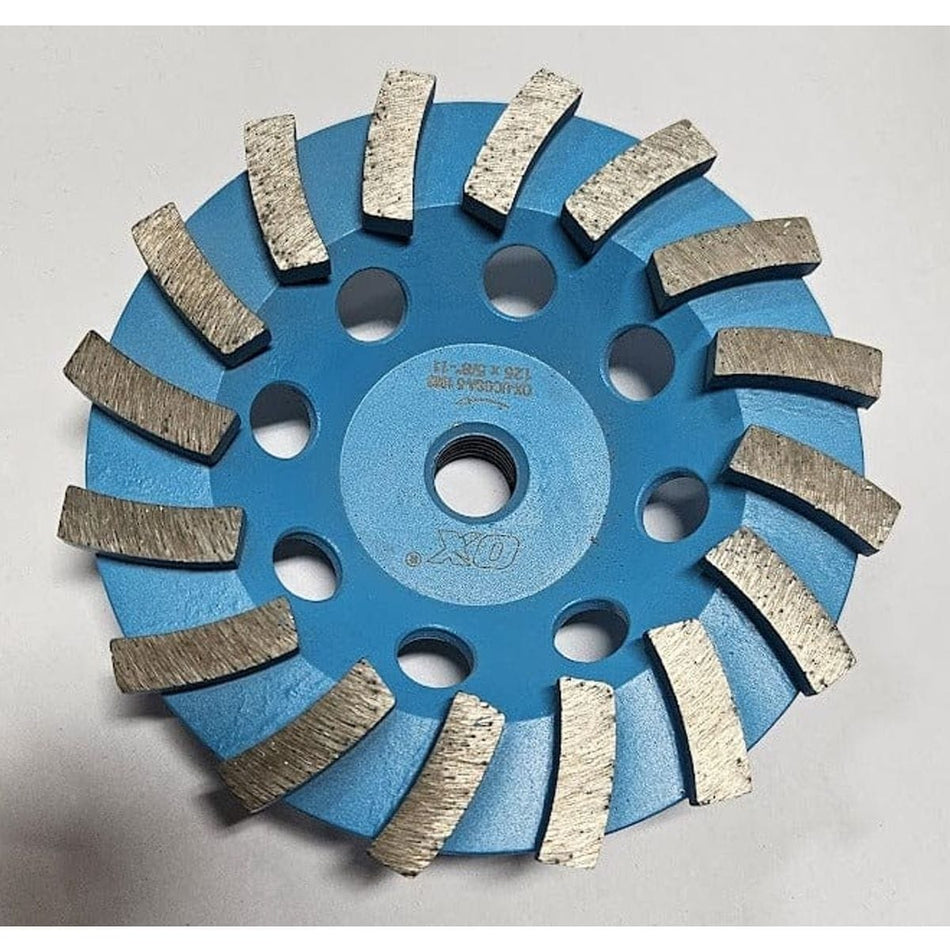 A top-down view of the OX Tools 5-inch single row diamond cup grinder featuring blue steel construction and aggressive spiral-segmented diamond teeth for heavy-duty concrete and stone grinding.