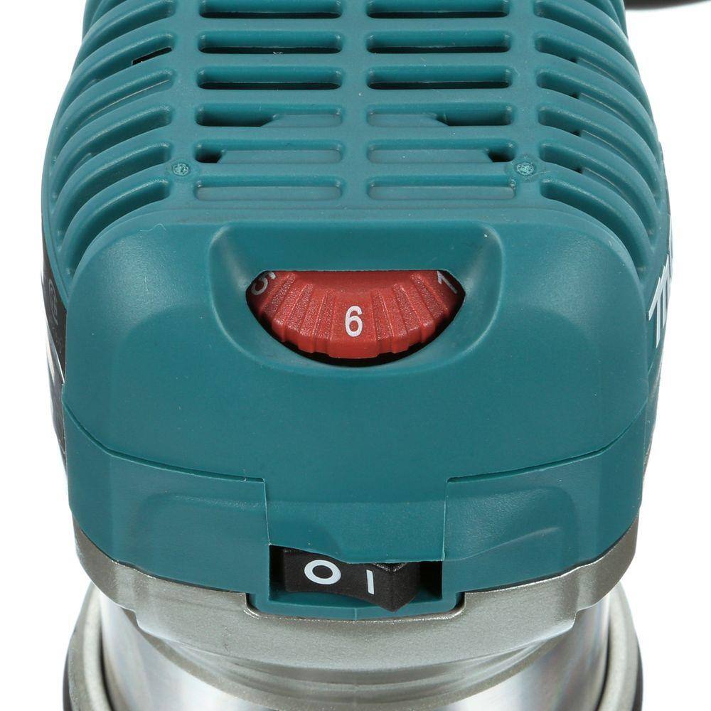 Close-up of the top motor housing on the Makita RT0701C router, highlighting the red variable speed control dial to adjust from 10,000 to 30,000 RPM, alongside the power switch.