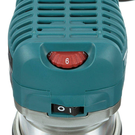 Close-up of the top motor housing on the Makita RT0701C router, highlighting the red variable speed control dial to adjust from 10,000 to 30,000 RPM, alongside the power switch.