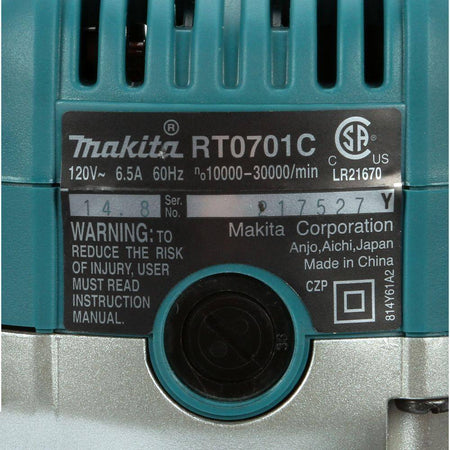 Detailed view of the manufacturer specification label on the Makita RT0701C compact router, indicating the 120V, 6.5 Amp power rating and variable speed range.