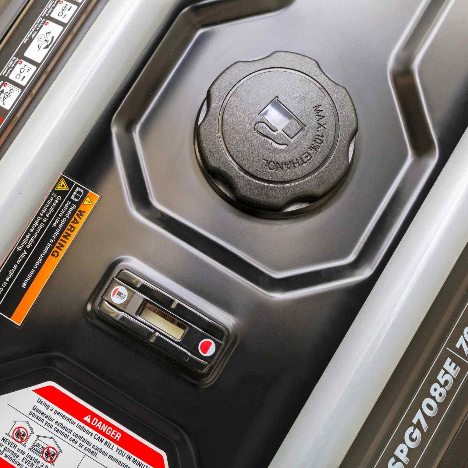 Top-down view of the black 6.1-gallon fuel tank showing the built-in fuel gauge, gas cap, and operational safety labels.