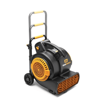 The image shows a large, black and orange fan with a circular grill, positioned at a slight angle. The fan has a handle that extends upwards and rests on small wheels, designed for easy movement.