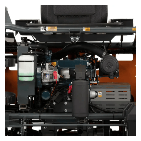  A close-up view of the engine compartment of a piece of heavy machinery, possibly a concrete trowel based on our previous conversation. You can feel the distinct shapes of an internal combustion engine with various components like hoses, wires, and filters. There's a white translucent fluid reservoir on the left, and a black air filter housing on the right. The engine block itself has a textured surface and various bolted-on parts. The overall impression is of a complex mechanical system designed for power