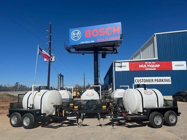 A wide outdoor shot of multiple Simpson 95404 mobile water trailers lined up in a professional equipment yard, featuring large 525-gallon white tanks and dual-axle DOT-certified chassis under a clear blue sky.