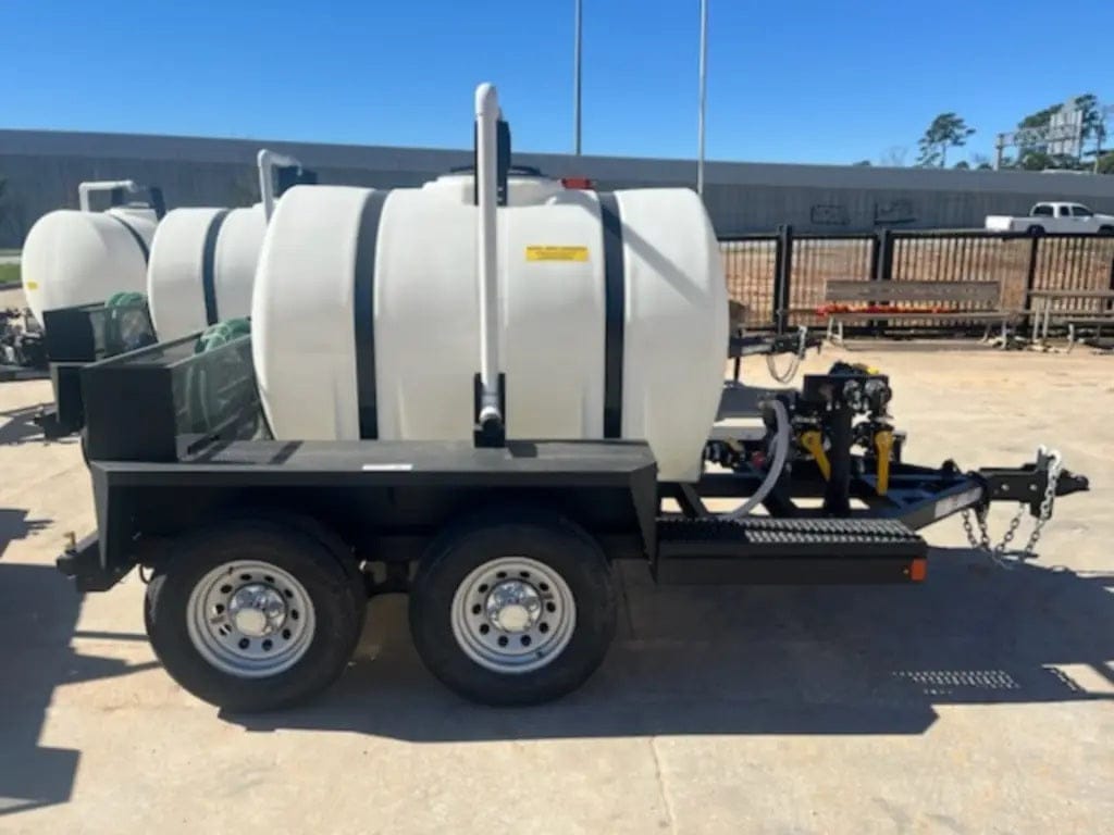 A direct side view of the 525-gallon water transport trailer emphasizing the balanced dual-axle design and the front-mounted engine and pump assembly platform.