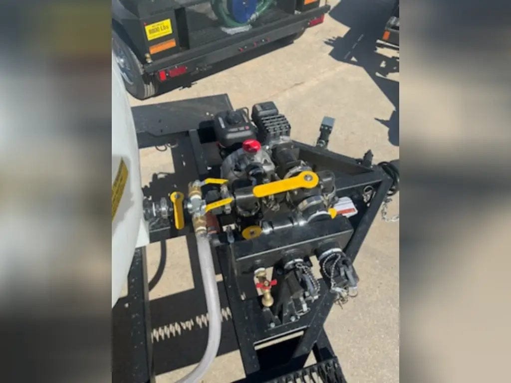 A top-down detailed view of the Simpson trailer's plumbing manifold and control valves, featuring high-visibility yellow handles for easy operation of the water distribution system.