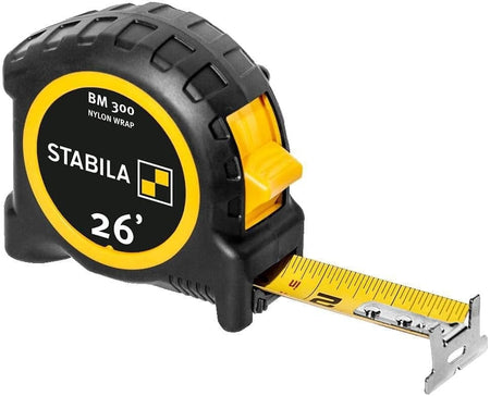 Angled studio view of the Stabila BM 300 tape measure with the yellow blade extended, showing the rugged black housing and 26-foot branding.
