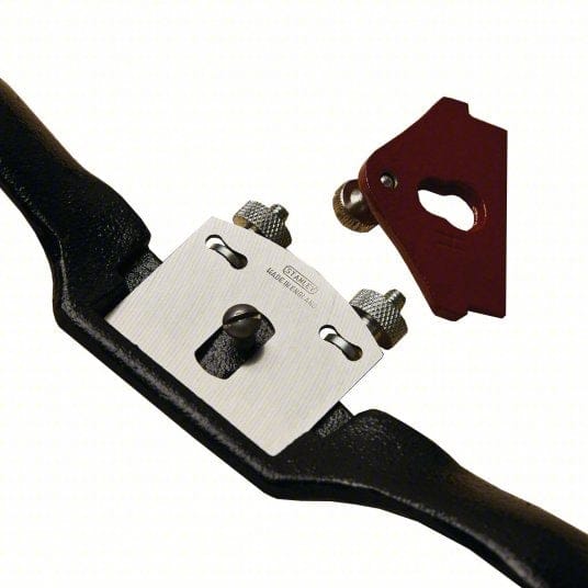 View of the spoke shave with the red lever cap removed and set aside, exposing the rectangular steel cutting blade seated on the adjustment mechanism.