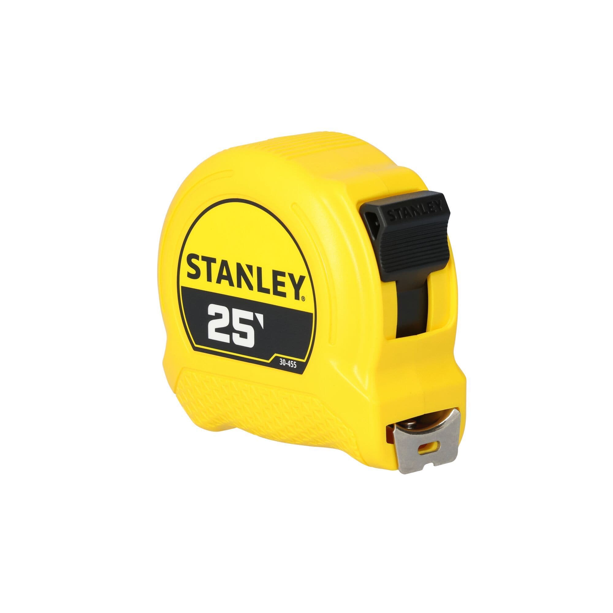 A three-quarter front angle studio product layout of the closed Stanley 25' tape rule, showcasing the black mechanical thumb-lock slide button and the front steel tape exit mouth slot.