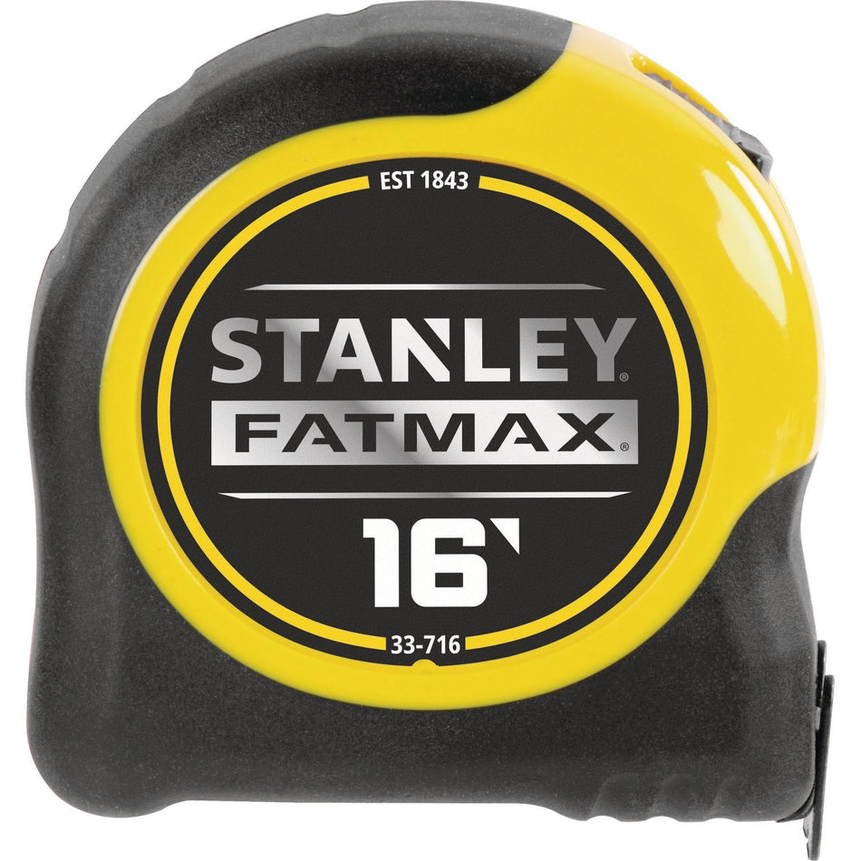 A direct side-profile studio photograph of the yellow and black Stanley FatMax 16-foot tape measure case, showcasing the circular center brand badge with the model numbers and full-scale product specifications against a pure white background.