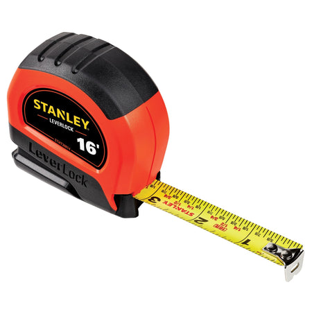 An isometric studio perspective shot of the Stanley 16' LeverLock measuring tape with its high-contrast yellow steel blade extended forward, demonstrating the pre-printed fractional layout marks and the riveted steel end hook resting on a clean white background.