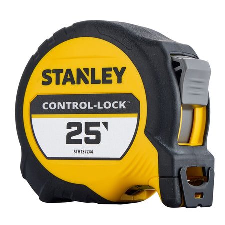 An angled three-quarter perspective studio shot of the closed yellow and black Stanley Control-Lock tape rule, highlighting the textured grey mechanical slide lock toggle button, the front mouth exit slot, and the dual-sided multi-catch hook.