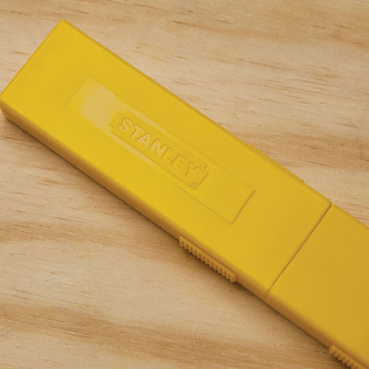 Yellow protective storage case for Stanley snap-off utility blades keeps replacement blades clean and easily identifiable on jobsites.