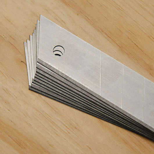 Stacked set of professional snap-off utility blades with visible score lines for easy edge breaking and fresh cutting points.