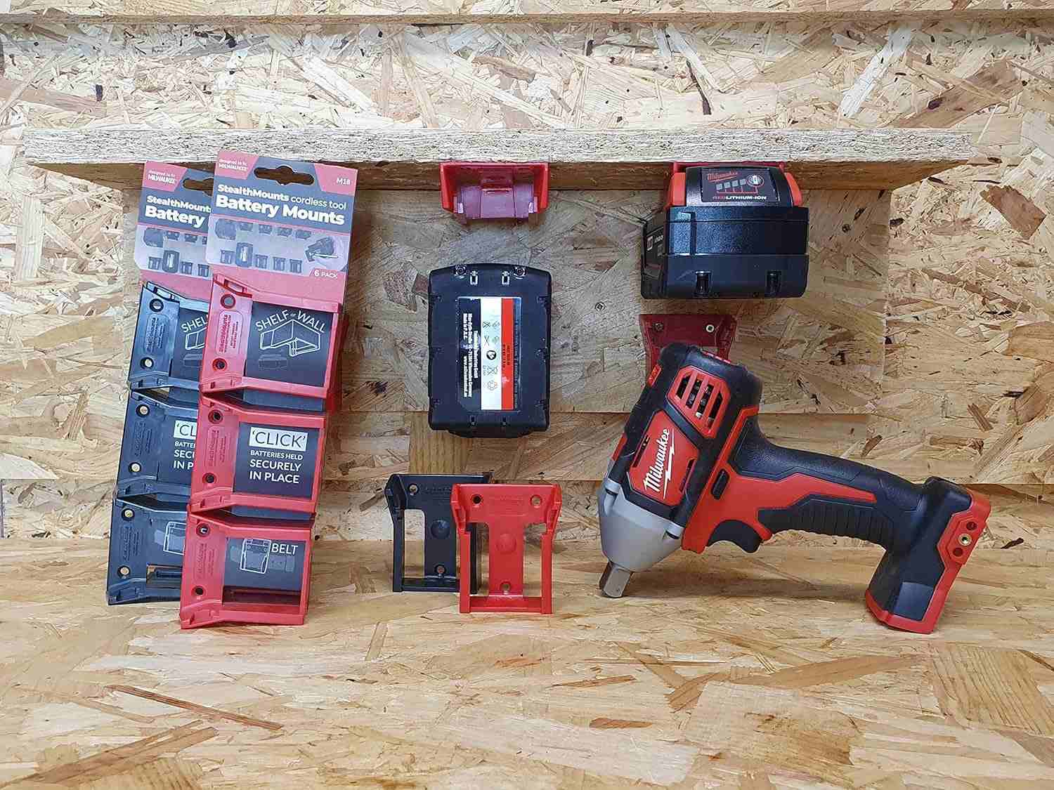 Workshop scene demonstrating Milwaukee M18 batteries securely mounted under a shelf and on a wall using StealthMounts holders.