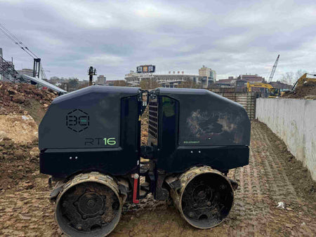 The Third Coast Equipment RT16Y trench roller in operation on a construction job site, demonstrating its deep-cycle compaction performance on cohesive soil and mud within a foundation excavation.
