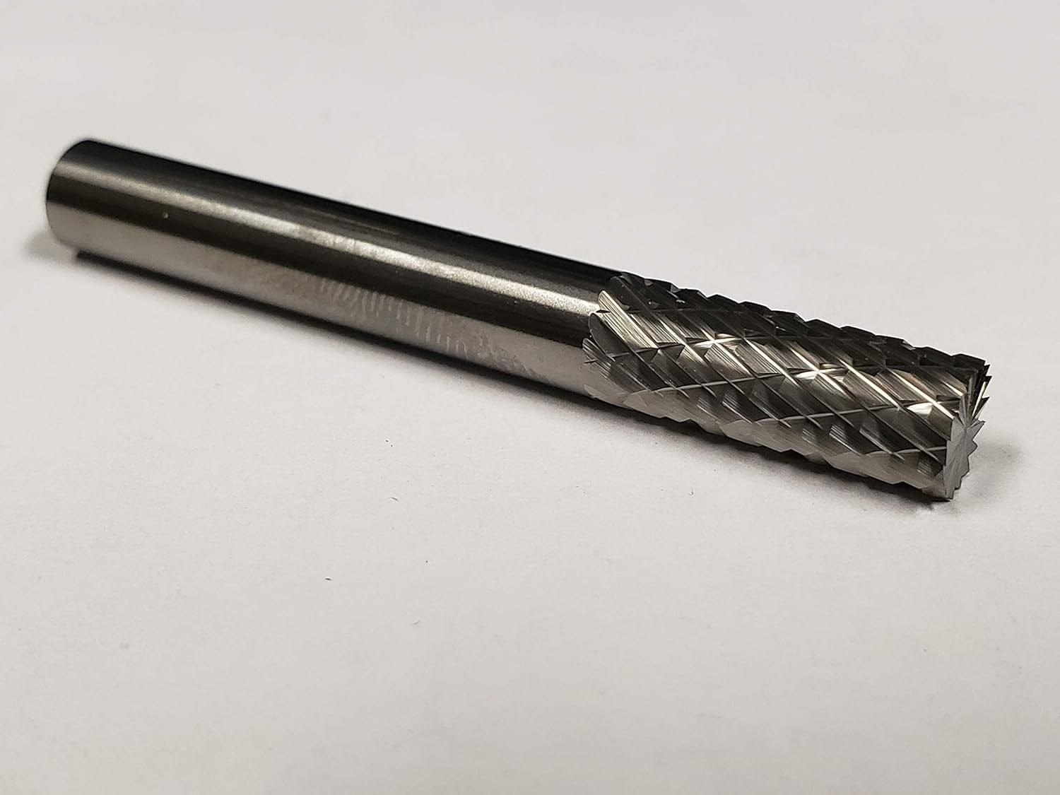 A studio shot of the UCT Gem Carbide SB1 burr lying on a white surface.