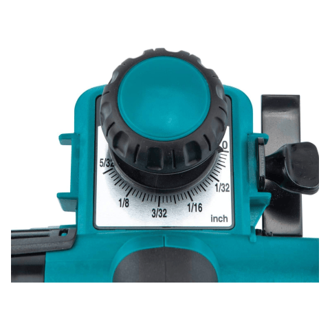 This is a close-up view of the depth adjustment knob and scale on a Makita KP0810 planer. The teal knob with a textured black grip is positioned above a white scale marked in inches with increments down to 1/32". The scale shows the depth of cut that can be set for the planer.