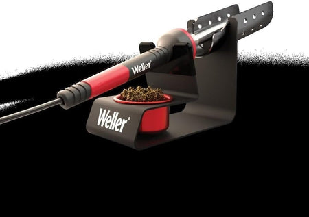 An angled studio shot of the Weller metal stand with a soldering iron in the resting position, highlighting the safety features and compact footprint for professional electronics workbenches.