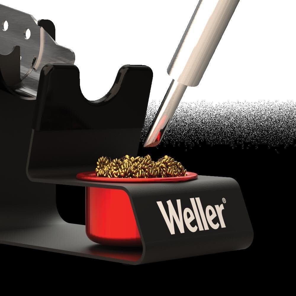 A close-up view of a soldering iron tip being cleaned in the brass wire coils of the Weller WLACCH1 dry tip cleaner, demonstrating the effective removal of oxidation and solder residue.
