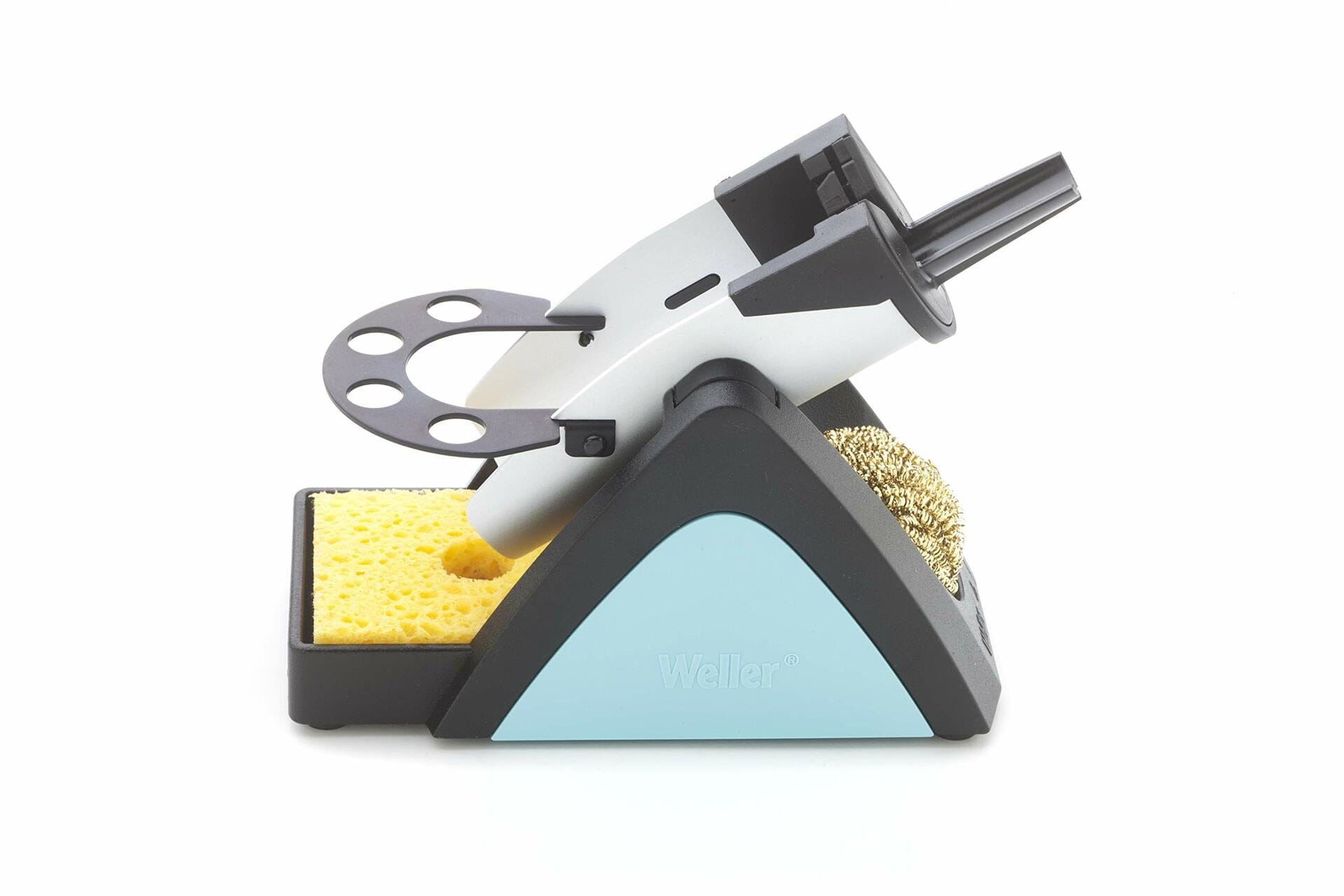 Weller soldering iron stand with metal holder, brass wire cleaner, and yellow sponge. The triangular base features a light blue panel labeled “Weller.” Designed to safely hold and clean soldering irons during electronics work.