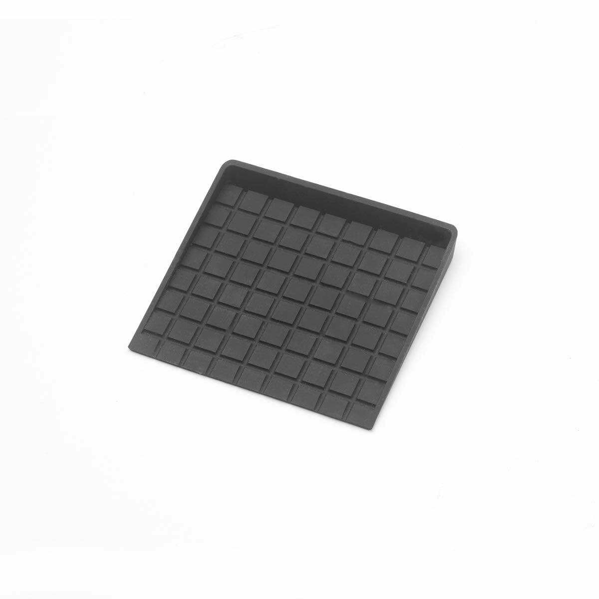 Black rectangular anti-slip mat with raised square grid pattern. Likely used as a protective surface or tool pad in soldering or electronics workspaces. Slightly raised edge visible on one side for containment or grip.