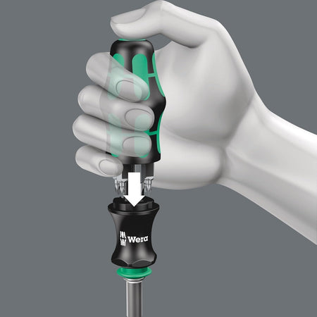 Instructional graphic showing a hand engaging the bit storage magazine of the Wera Kraftform handle by pressing the green release button at the base of the grip.
