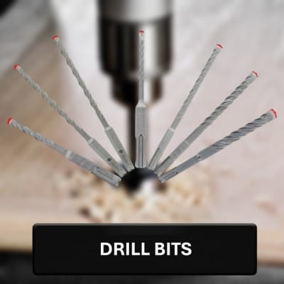 Set of drill bits being driven into a wooden surface with a blurred background.