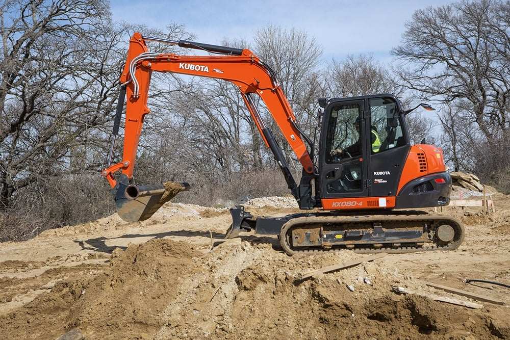 Kubota KX080-4 Power Utility Excavator resting on a large mound of dirt.