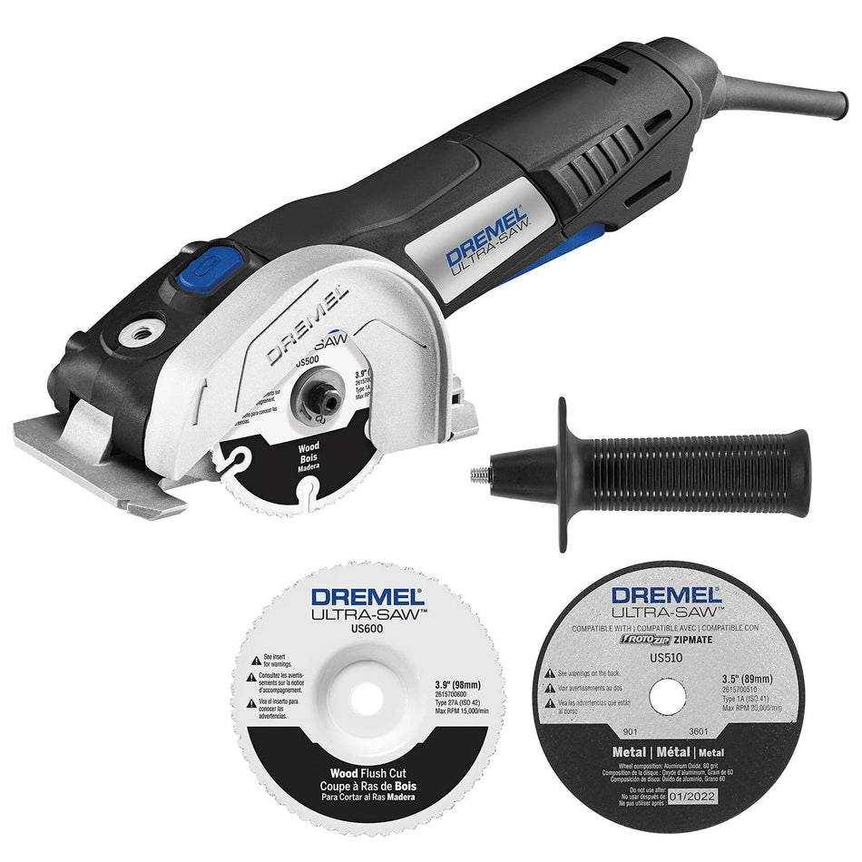 The image displays a Dremel Ultra-Saw kit, featuring the compact handheld saw in black and silver with a circular blade attached. Also included are two additional circular cutting blades – one for wood and one for metal – and a black auxiliary handle that can be attached to the saw.